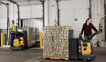 Two workers distributing pallets full of materials with Cat walkie end riders